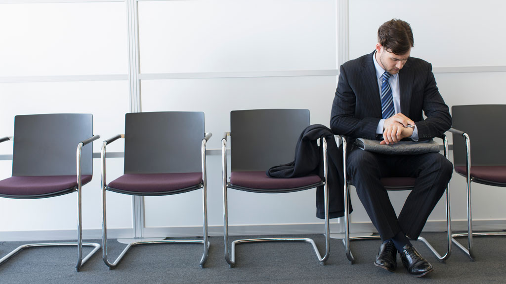 Professionnel consultant sa montre dans file d'attente bureau de poste